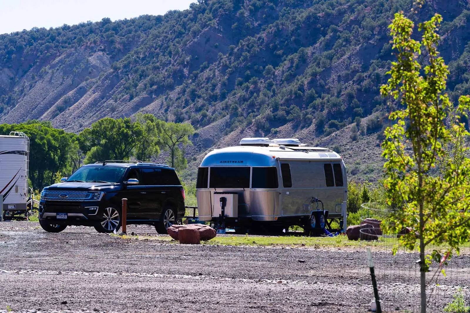Airstream travel trailer and tow vehicle parked on a level full-hookup RV site at Riverdance RV Resort in Gypsum, Colorado